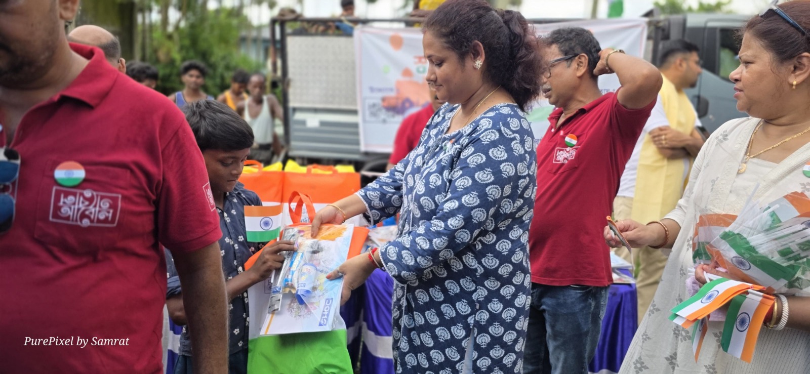 A volunteer presenting an Independence Day care package to a child
