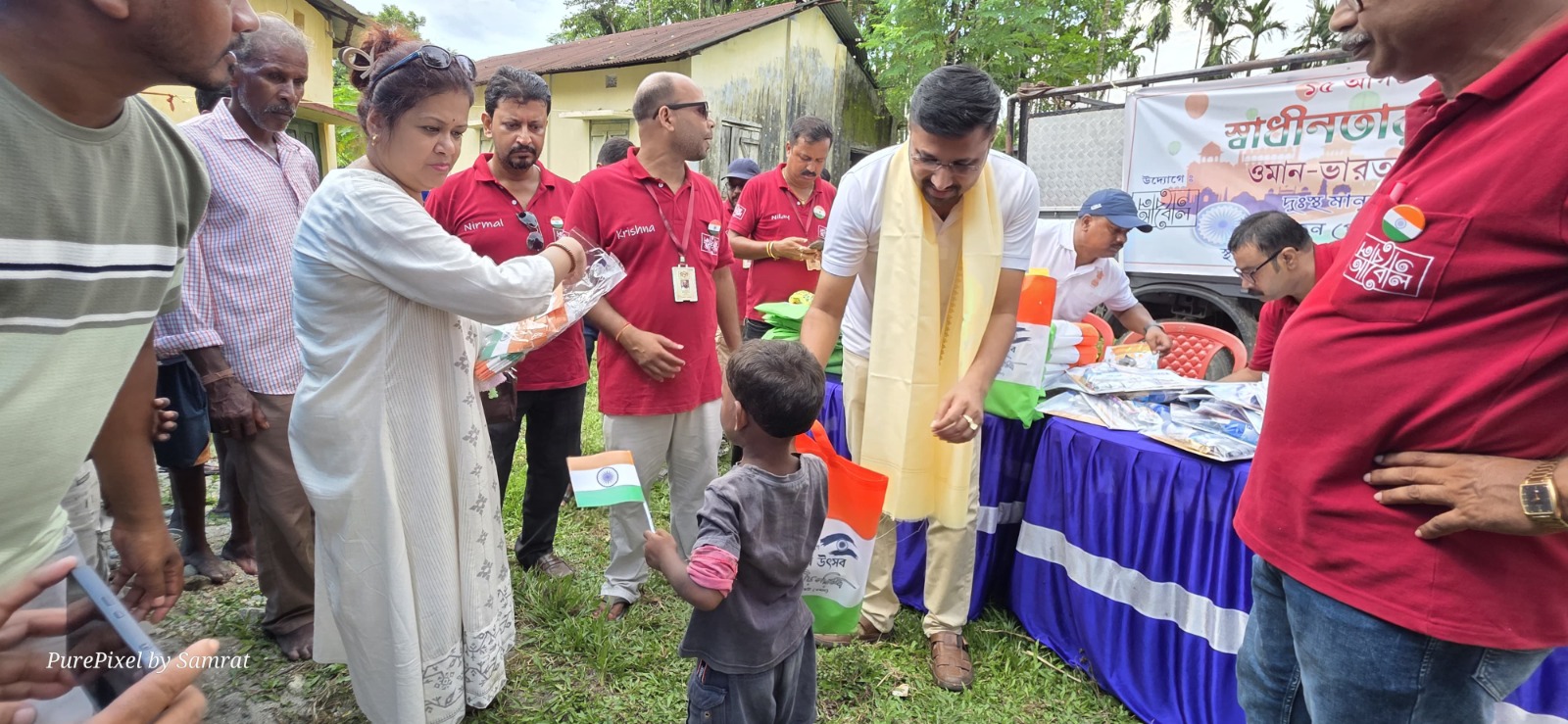 A child holding the Indian flag while receiving a care package