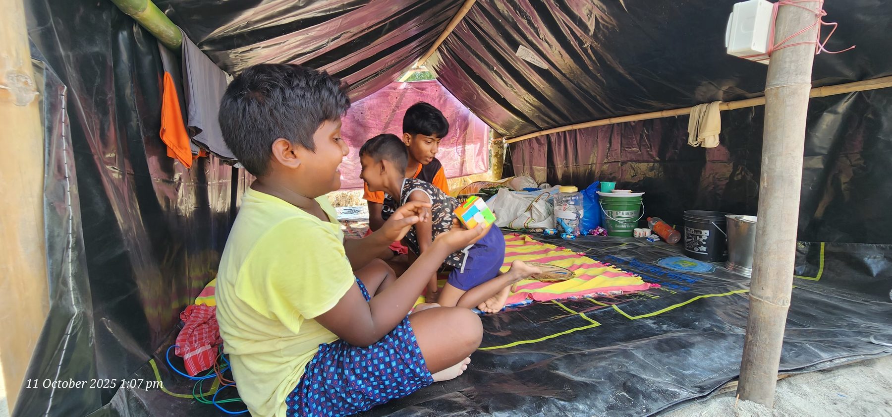 A family sheltering under a tarpaulin after the flood