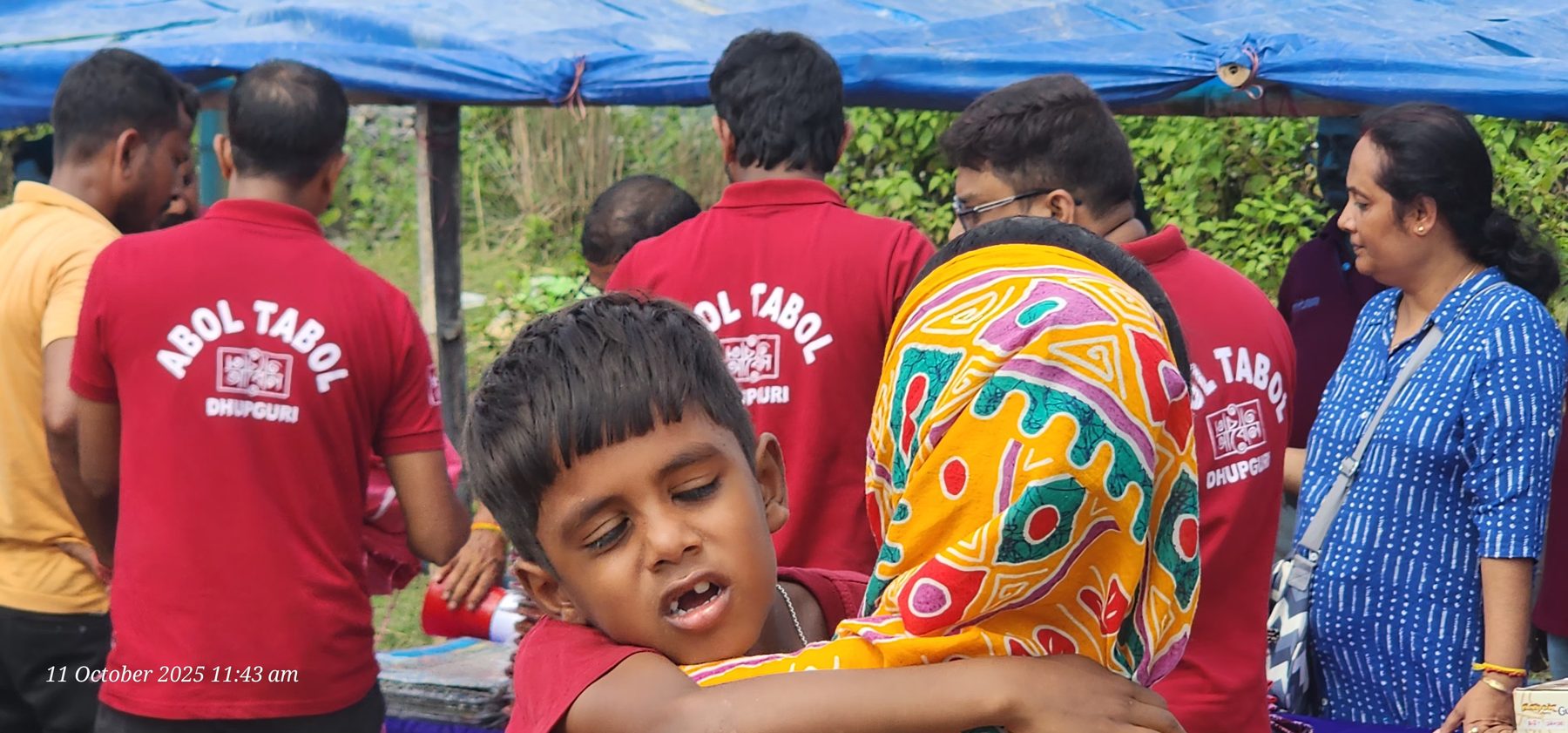 A volunteer comforting a child during flood relief distribution