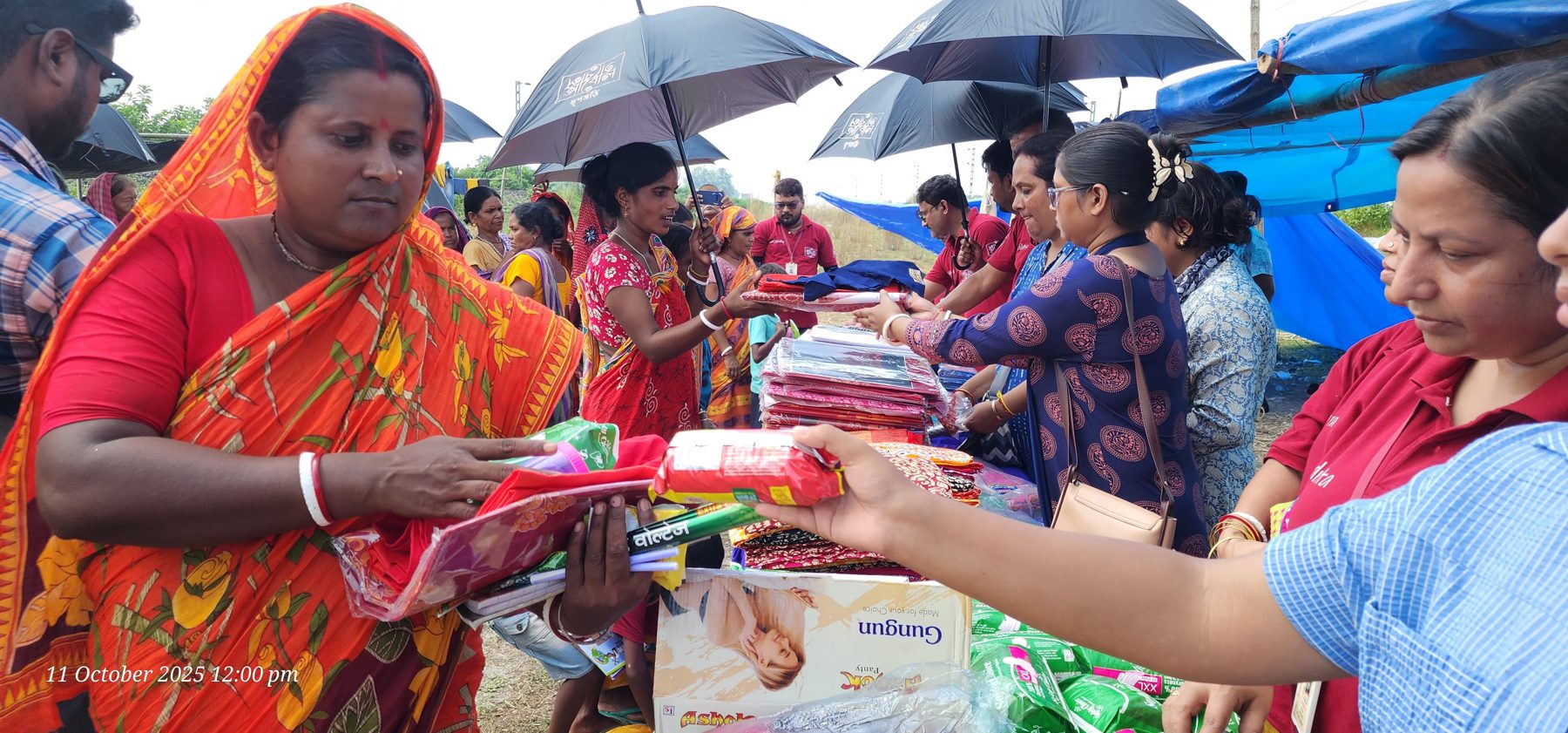 A woman receiving relief supplies from Abol Tabol volunteers