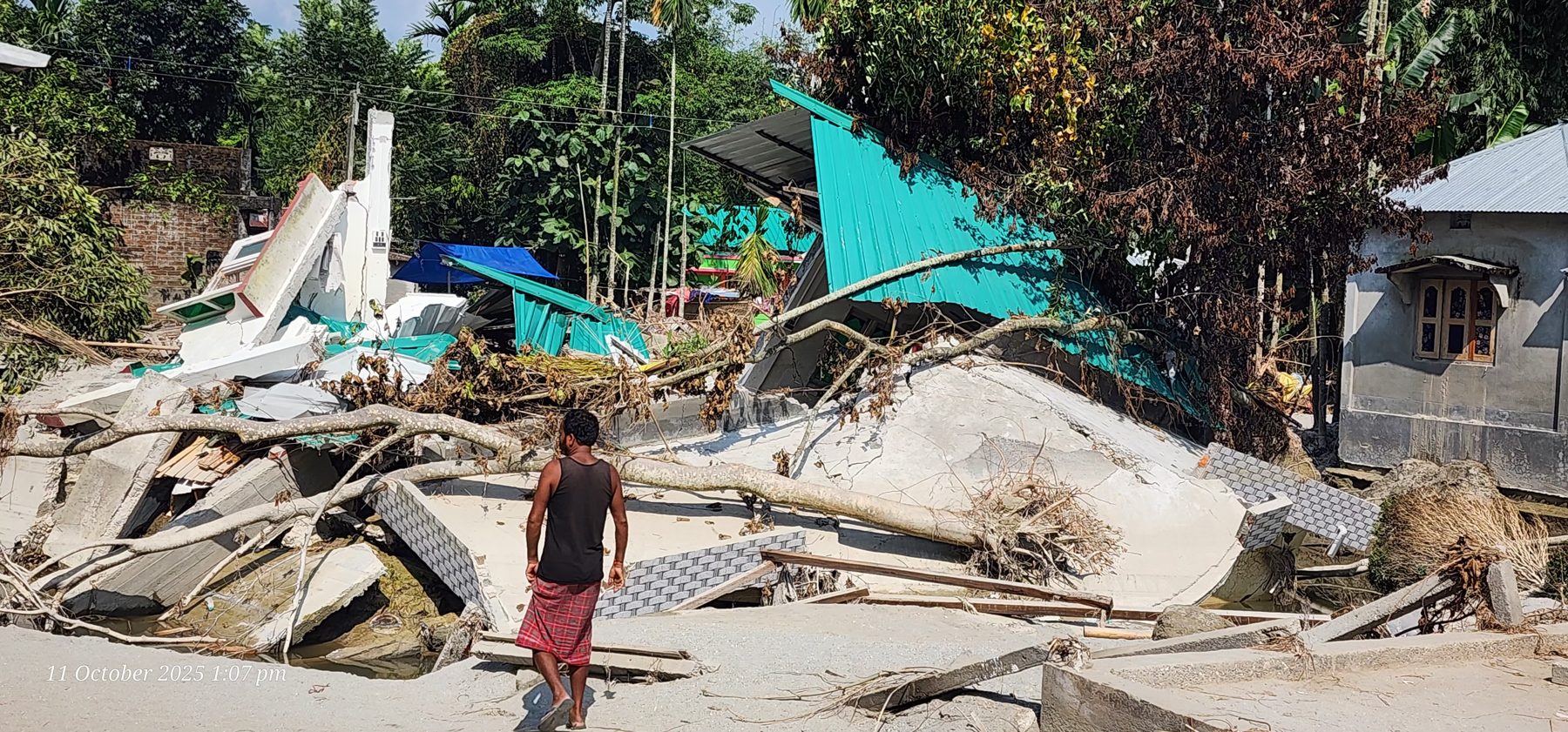 A home damaged by the flood, surrounded by sand and debris
